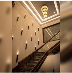 a staircase with lights on the ceiling and a chandelier hanging from the ceiling