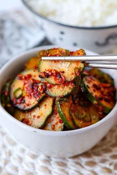 a white bowl filled with food and chopsticks