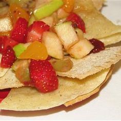 a plate filled with fruit and chips on top of a table