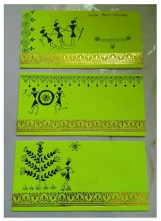 three green cards with gold trims and designs on the front, one in yellow