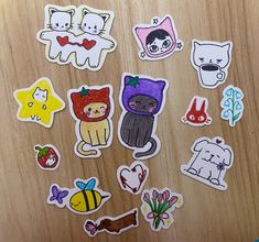 several stickers on a wooden surface with various animals and other things in the background