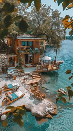 an image of a house on the water with chairs and umbrellas in front of it