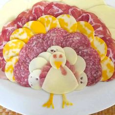 a turkey and ham platter on a white plate with yellow circles around the turkey