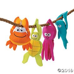 three stuffed animals hanging on a rope with eyes and hands attached to the string,