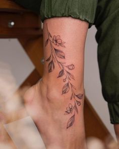 a woman's foot with a flower tattoo on her left side and the bottom part of her leg