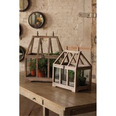 two small white lanterns sitting on top of a wooden table