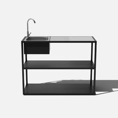 a black sink and shelf with a faucet on the top, against a white background