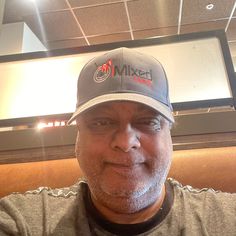 a man wearing a hat sitting in a booth