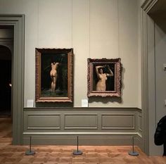 two paintings hanging on the wall in a museum