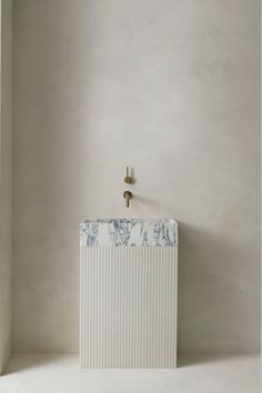 a white radiator sitting in the corner of a room with a wall mounted faucet