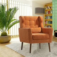 an orange chair sitting on top of a white rug in front of a book shelf