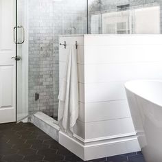 a white bath tub sitting next to a walk in shower