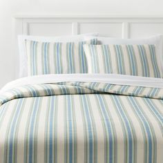 a bed with blue and green striped sheets