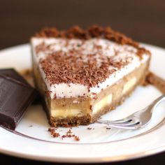 a piece of cake on a plate with a fork and chocolate bar next to it