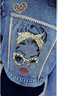 the back of a woman's jean jacket with an image of a cat on it