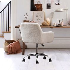 a white chair sitting on top of a wooden floor in front of a desk and stairs