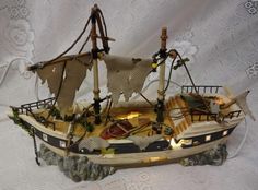 a small model boat with sails and lights