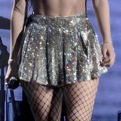 the back of a woman's skirt with sequins and fishnet stockings