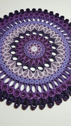 a purple and white paper doily with circles in the shape of flowers on it