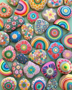 many colorful rocks are arranged together on the ground and one is painted with different colors