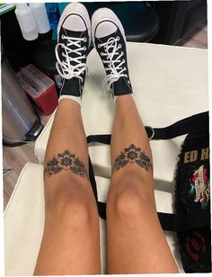 the legs and ankles of a woman with tattoos on her feet, sitting on a table