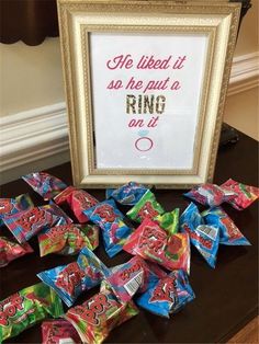 there are candy candies laid out on the table next to a framed sign that says, he liked it so he put a ring on it