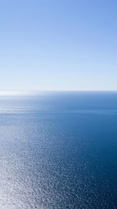 an airplane flying over the ocean on a clear day