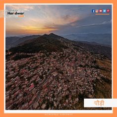 an aerial view of a city with mountains and hills in the background at sunset or sunrise