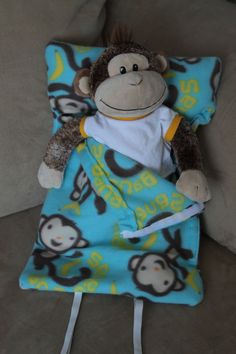 a stuffed monkey laying on top of a blue blanket