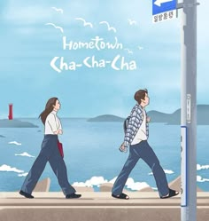 two people walking down the sidewalk next to a sign that says home town cha - sha - cha