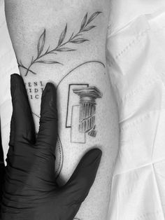 a black and white photo of a person's arm with a tattoo on it