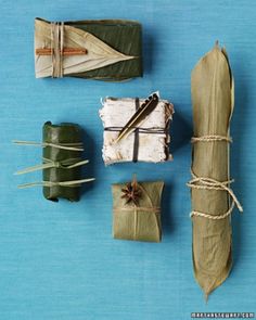 three different types of items made out of paper on a blue surface with twine