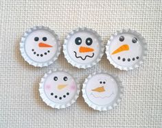 four bottle caps with snowmen painted on them