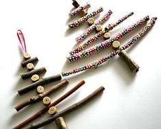 a group of small christmas trees made out of wood sticks and beaded with beads