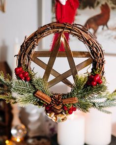 a wicker christmas ornament hanging from a table with candles and other decorations