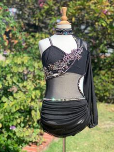 a mannequin wearing a black dress with beading on it