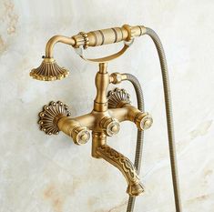 an antique style shower faucet with hand shower head and handset in gold