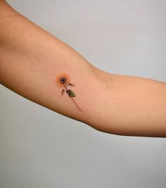 a small sunflower tattoo on the arm