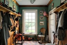 a room filled with lots of wooden shelves next to a large window and a white door