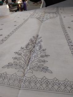 an embroidered table cloth with people sitting at tables in the background