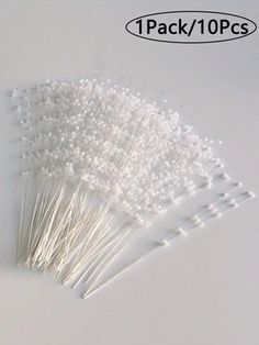 several white pins sitting on top of each other in front of a white background with the words pack / 10 pcs