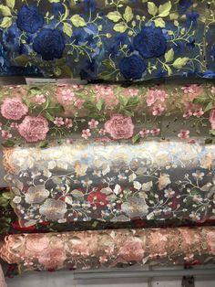 four rolls of fabric with flowers on them