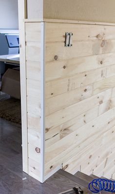 a room with wood paneling on the wall and a computer desk in the background