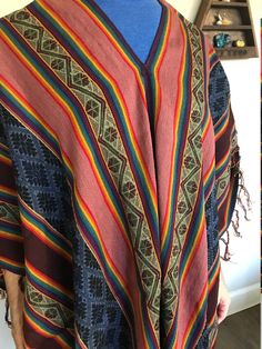 "This is a beautiful, soft, and colorful Andean poncho made by one of our most talented weavers. The natural fiber yarn is hand-dyed and woven into beautiful patterns and color arrangements. Perfect to keep you warm around ceremonial fires! There is yarn fringe at the bottom & sides. Model height: 5'8\". One size fits most adults. Unisex. Dimensions: 72\"x44\"  Peruvian woven textiles are incomparable in their quality and beauty. Add this to your collection today! We are a non-profit organizatio Peruvian Poncho, Yarn Fringe, Mens Poncho, Alpaca Poncho, Feminine Earrings, Woven Textiles, Aztec Calendar, Wool Poncho, Non Profit Organization