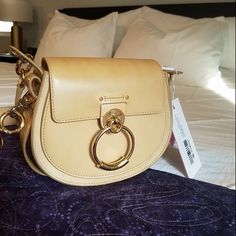 Certified Authentic (From Reputable Reseller, But Poshmark Will Authenticate As Well) Chloe Tess Handbag In Light Natural Leather (Color Is Bleached Brown) And Gold Tone Hardware. Wide Strap And Dustbag Included, With Authenticity Card. Perfect Condition, Never Worn By Me. Added A Daylight Pic For True Color! - Width: 20.5 Cm / 8.1" - Height: 17.5 Cm / 6.9" - Depth: 6 Cm / 2.4" - Long Strap Length Min: 49 Cm / 19.3" - Long Strap Length Max: 53 Cm / 20.9" - Short Strap Length: 22.5 Cm / 8.6" Luxury Saddle Bag With Detachable Strap For Shopping, Chloe Mini Tess Day Bag, Designer Evening Saddle Bag, Elegant Shoulder Saddle Bag, Satchel Saddle Bag With Dust Bag For Evening, Classic Saddle Bag With Gold-tone Hardware For Shopping, Designer Shoulder Bag With Metal Hardware For Everyday Luxury, High-end Beige Shoulder Bag With Gold-tone Hardware, Designer Saddle Bag With Gold-tone Hardware And Top Handle