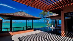 the sun is shining on an outdoor patio with a view of the ocean and mountains