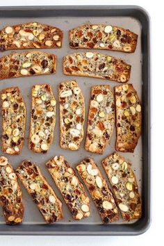 several slices of bread with nuts and other toppings on a baking sheet, ready to be baked