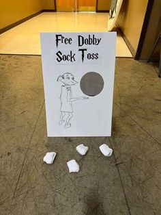 there is a sign that says free dobby sock toss on the floor with pieces of paper around it