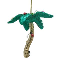 a christmas ornament hanging from a palm tree