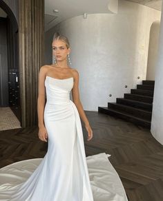 a woman in a white dress standing on a bed